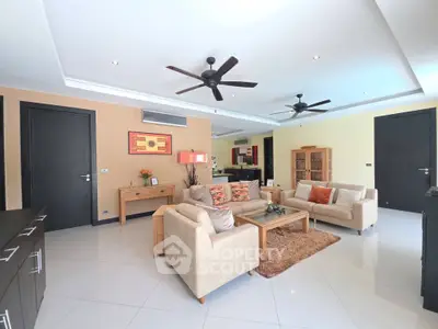 Spacious modern living room with elegant decor and ceiling fans, perfect for relaxation and entertainment.