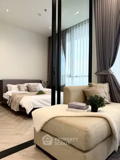 Luxurious bedroom with elegant decor and floor-to-ceiling windows offering natural light and a cozy seating area.