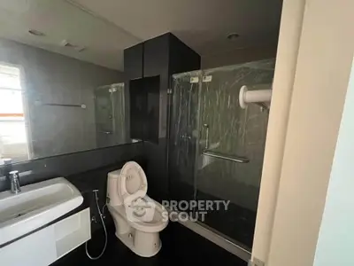 Modern bathroom with sleek design featuring glass shower and contemporary fixtures.