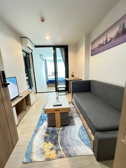 Modern living room with stylish decor and open view to bedroom