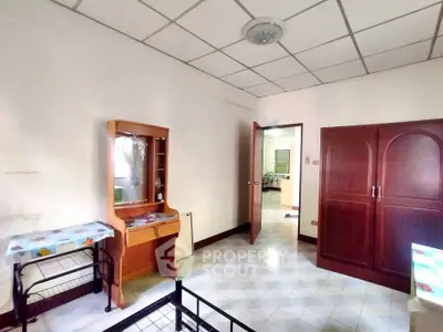 Spacious bedroom with wooden furniture and tiled flooring in a cozy home.