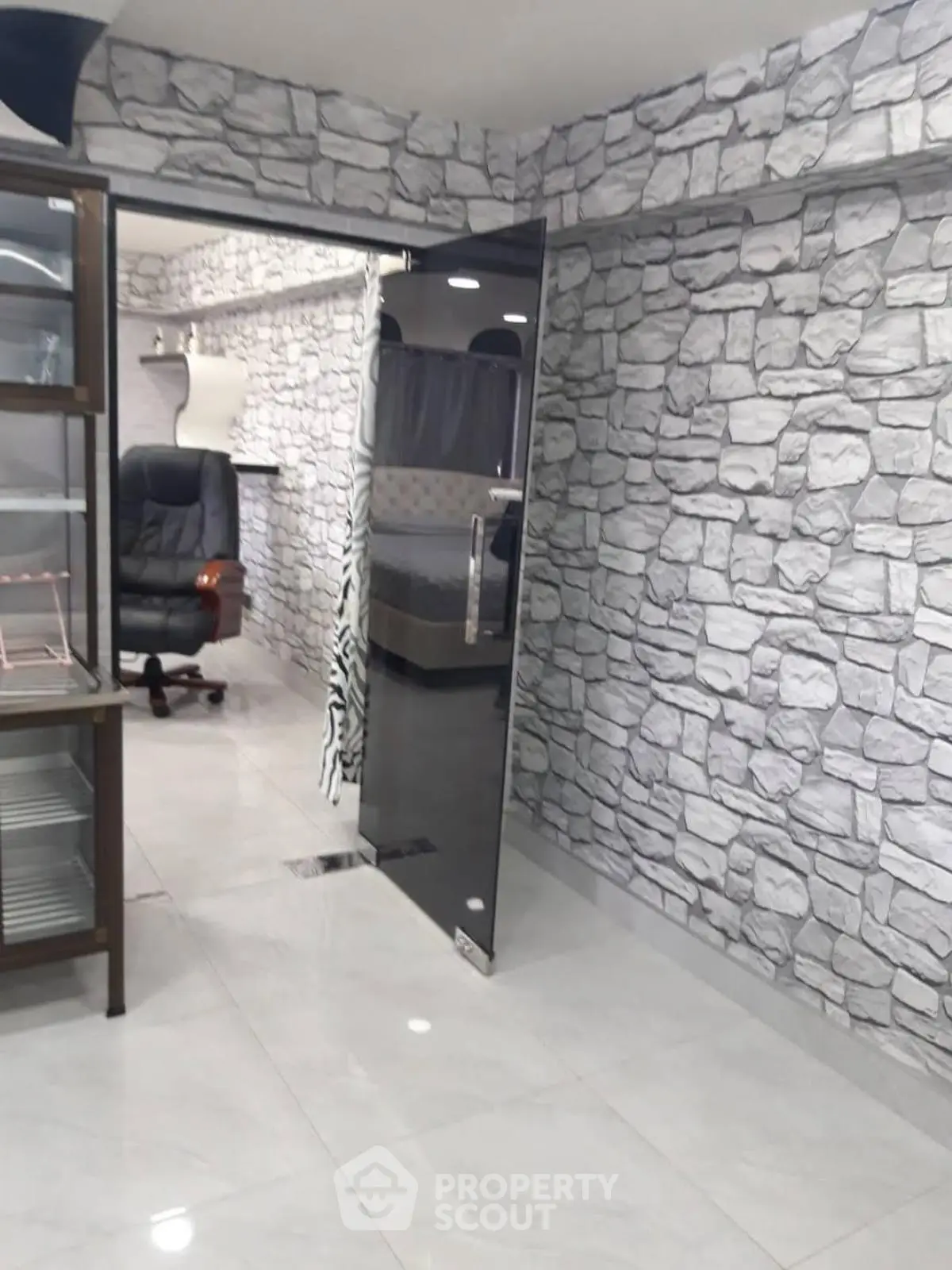 Modern office space with stone-patterned walls and glass door