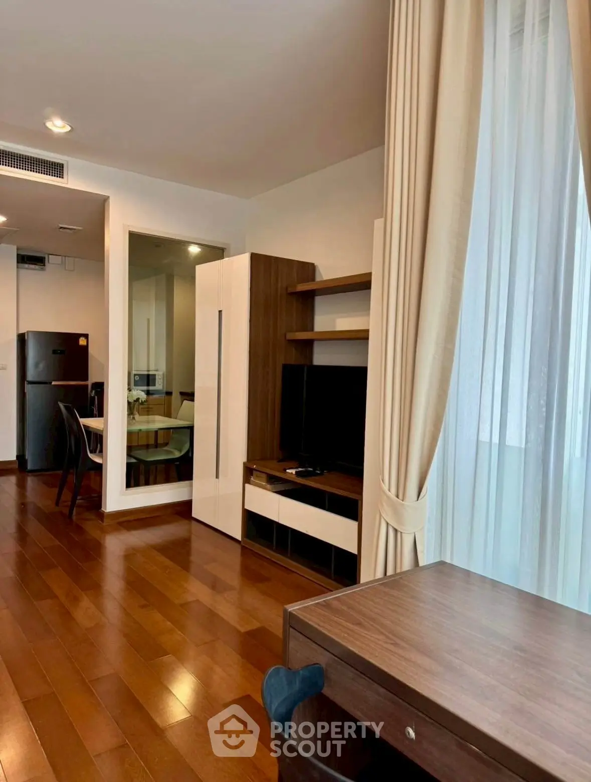 Modern living room with wooden flooring and elegant furniture in a stylish apartment.