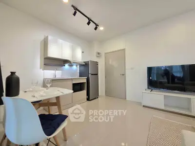 Modern living room with sleek kitchen and stylish decor in a contemporary apartment.