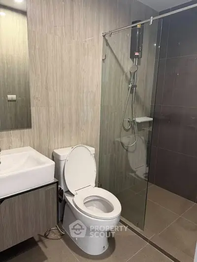 Modern bathroom with sleek design featuring a glass shower and contemporary fixtures.