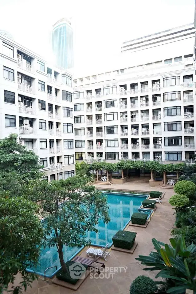 Luxurious apartment complex with pool and lush greenery in urban setting