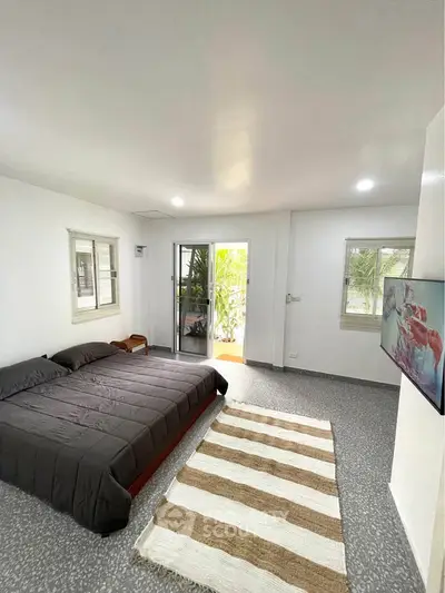 Spacious bedroom with modern decor and balcony access in a stylish apartment.