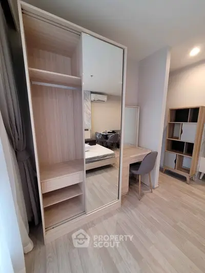 Modern bedroom with sleek wardrobe and cozy study area in stylish apartment