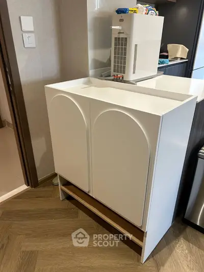 Modern kitchen storage unit with sleek design and wood flooring