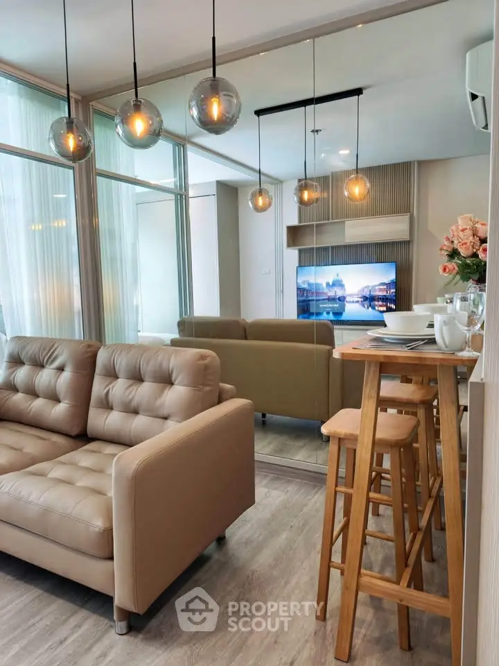 Modern living room with stylish decor and open layout, featuring cozy seating and elegant lighting.