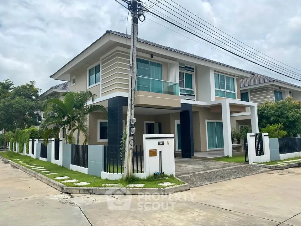 Modern two-story house with sleek design and lush green lawn in a serene neighborhood.
