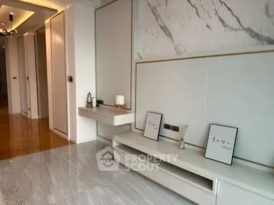 Modern living room with sleek design and marble accents, featuring stylish decor and warm lighting.