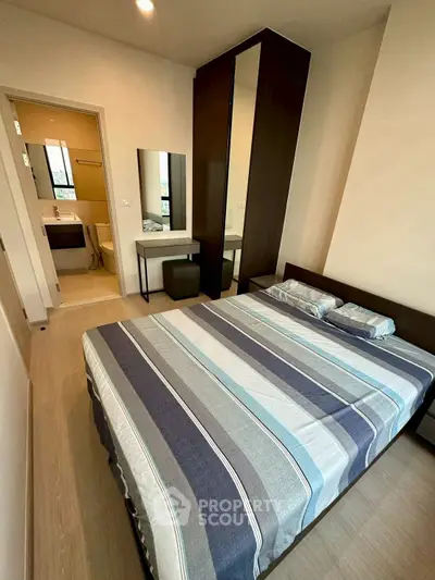 Cozy bedroom with modern decor and ensuite bathroom in stylish apartment