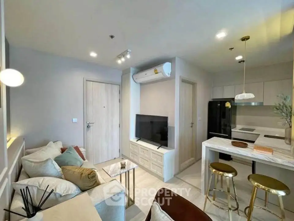 Modern living room with open kitchen, stylish decor, and cozy seating area.