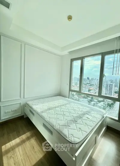 Bright bedroom with large window offering stunning city view