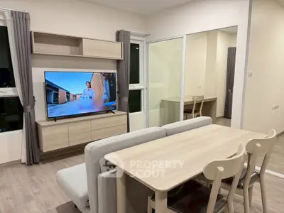 Modern living room with sleek furniture and large TV, perfect for relaxation.