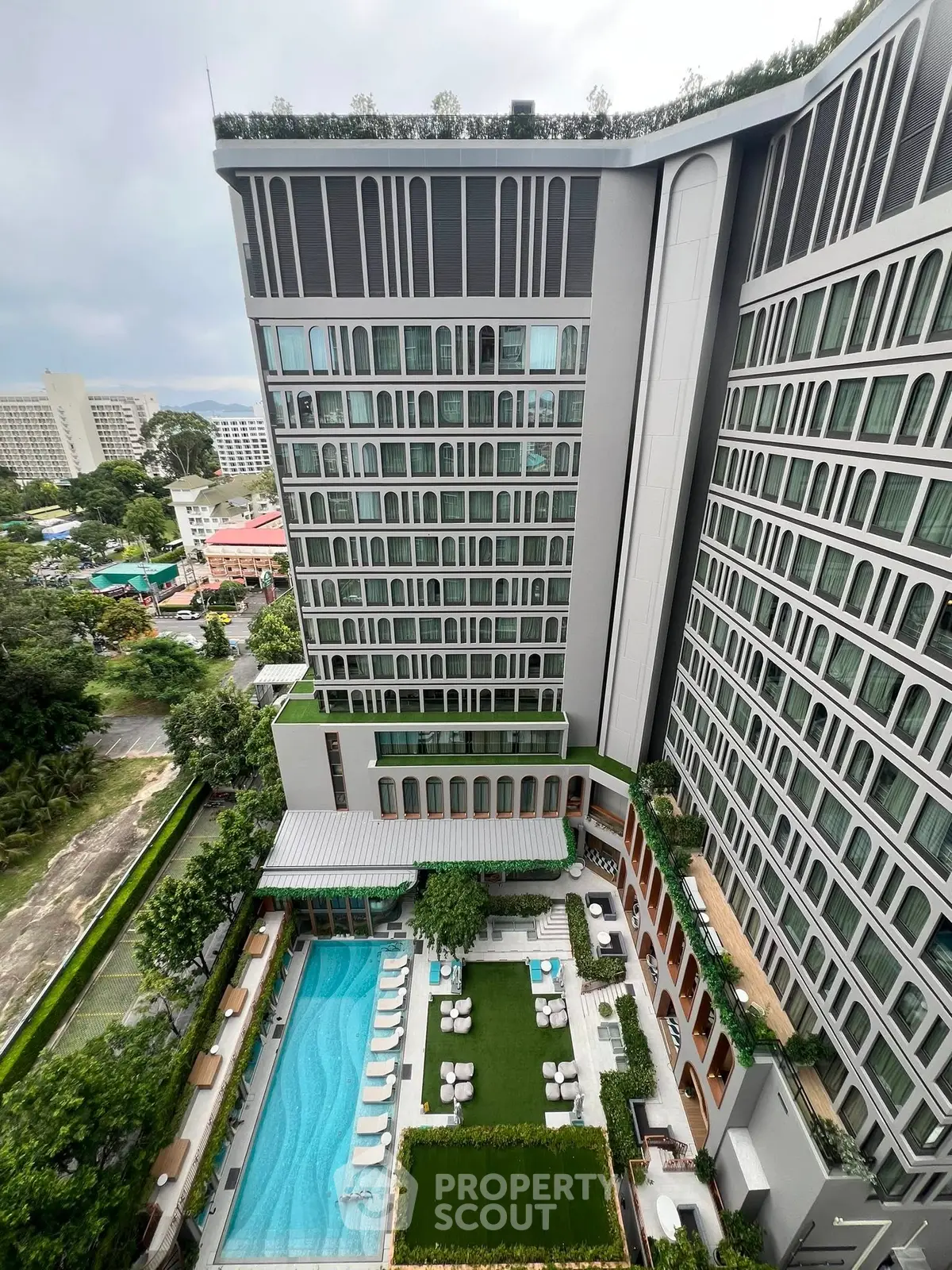 Luxurious high-rise building with stunning pool and garden view, perfect for upscale living.