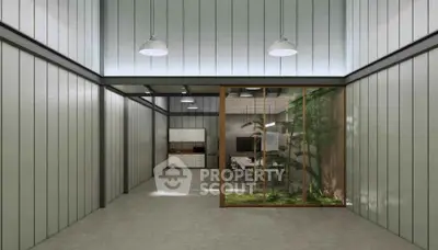 Modern industrial-style interior with high ceilings and glass partition overlooking a green courtyard.
