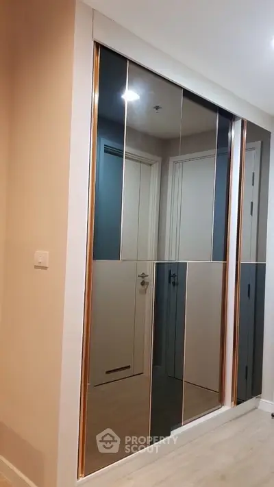 Modern hallway with sleek mirrored closet doors and minimalist design.