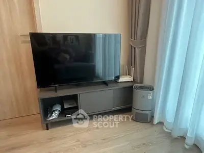 Modern living room with sleek TV stand and air purifier by large window.