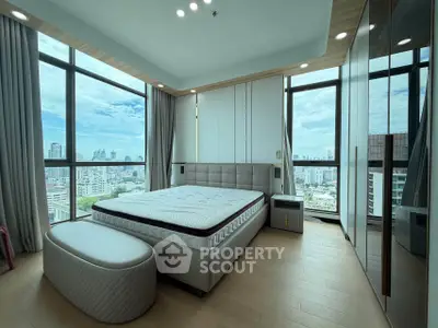 Luxurious bedroom with panoramic city views and modern furnishings in a high-rise apartment.