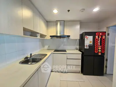 Modern kitchen with sleek cabinetry and stainless steel appliances in a stylish apartment.