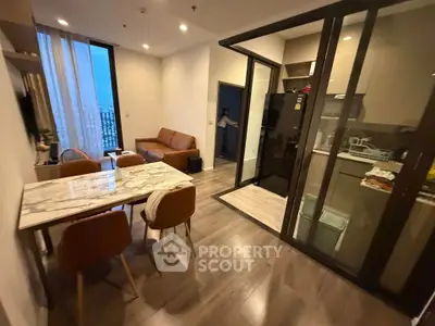 Modern apartment with open living and dining area, featuring a sleek kitchen and stylish furnishings.
