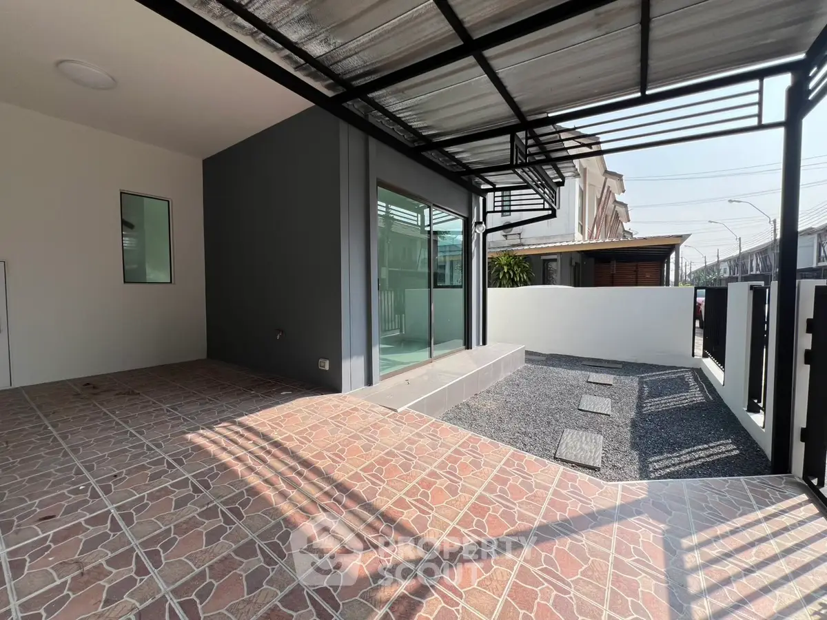 Modern patio with stylish tiles and sleek metal roofing in a contemporary home exterior.