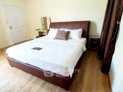 Spacious bedroom with elegant wooden flooring and luxurious bed in modern apartment.