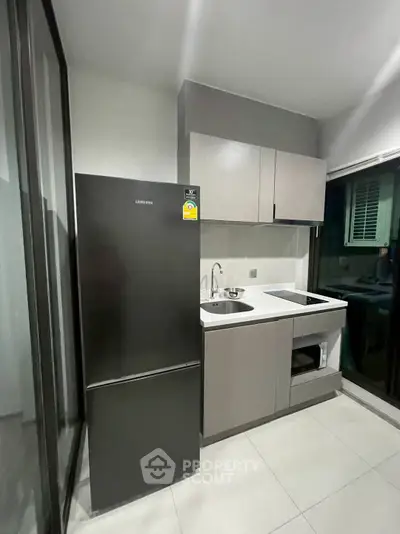 Modern kitchen with sleek cabinetry and Samsung fridge in compact layout.