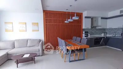 Modern open-layout living room and kitchen with stylish dining area and contemporary decor.