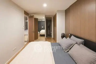 Modern bedroom with wooden accents and cozy bedding in a stylish apartment.