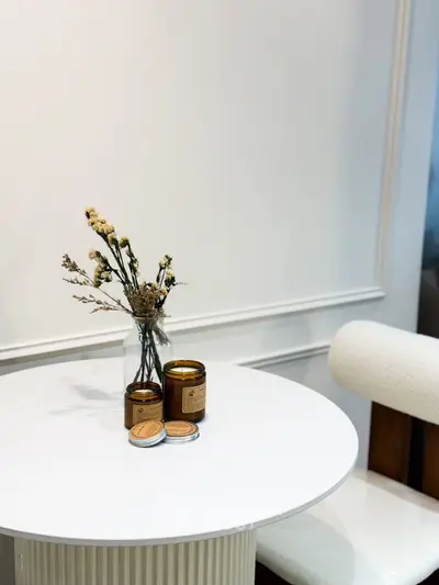 Elegant interior decor with round table and candles in modern living space.