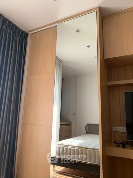 Modern bedroom with large mirror and wooden furniture