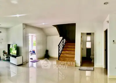 Spacious modern living area with staircase and TV setup