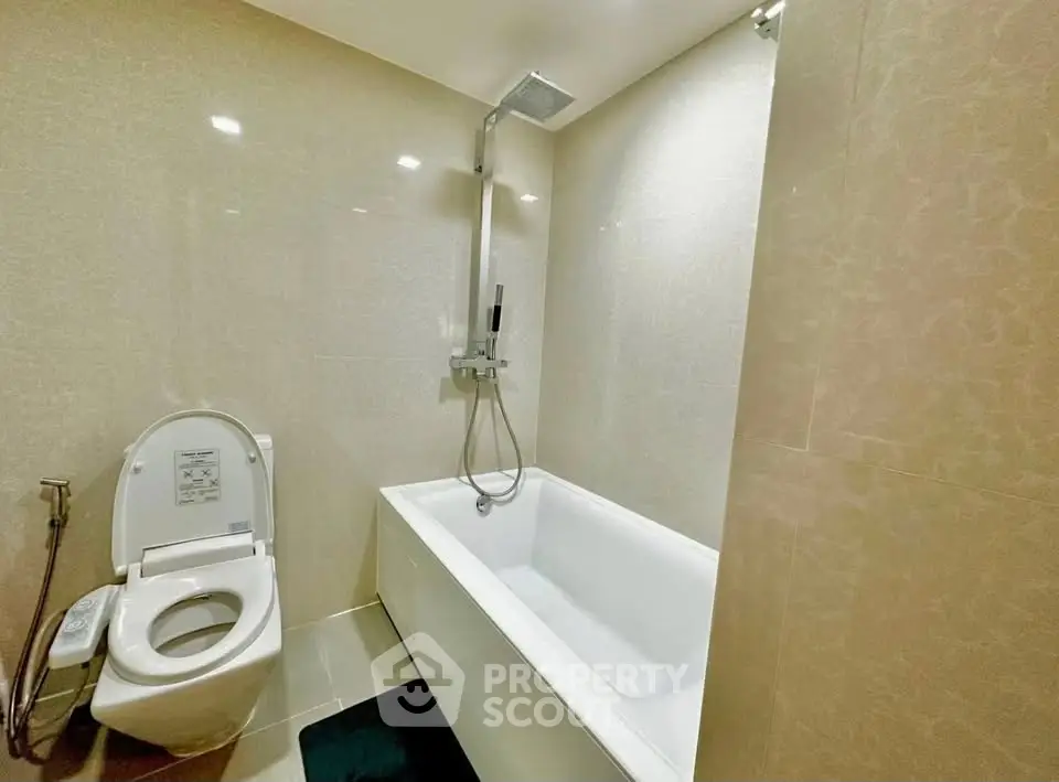 Modern bathroom with sleek bathtub and shower in a contemporary apartment.