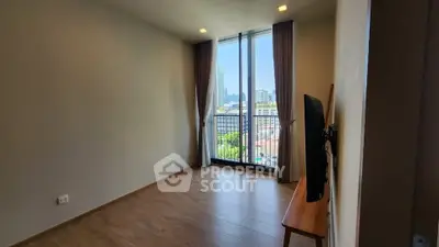 Spacious room with large window and city view, perfect for modern living.
