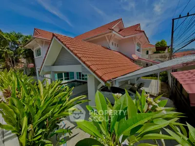 Charming suburban house with red-tiled roof and lush garden, perfect for family living.
