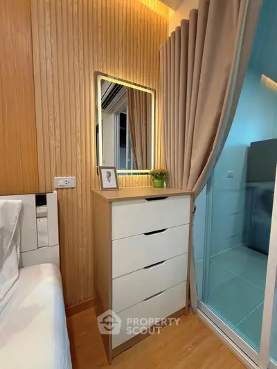 Modern bedroom with stylish wooden paneling and sleek dresser beside a cozy bed.