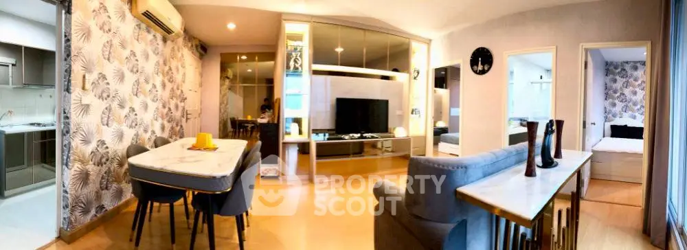 Stylish open-plan living room with modern decor and adjacent kitchen in a contemporary apartment.