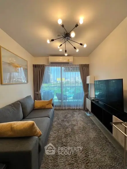 Modern living room with stylish lighting and cozy sofa, featuring a large window with a view.