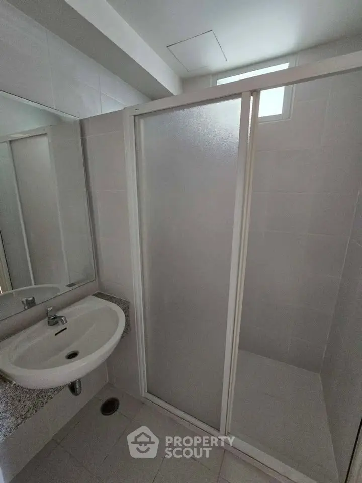 Modern bathroom with sleek shower enclosure and elegant sink design.