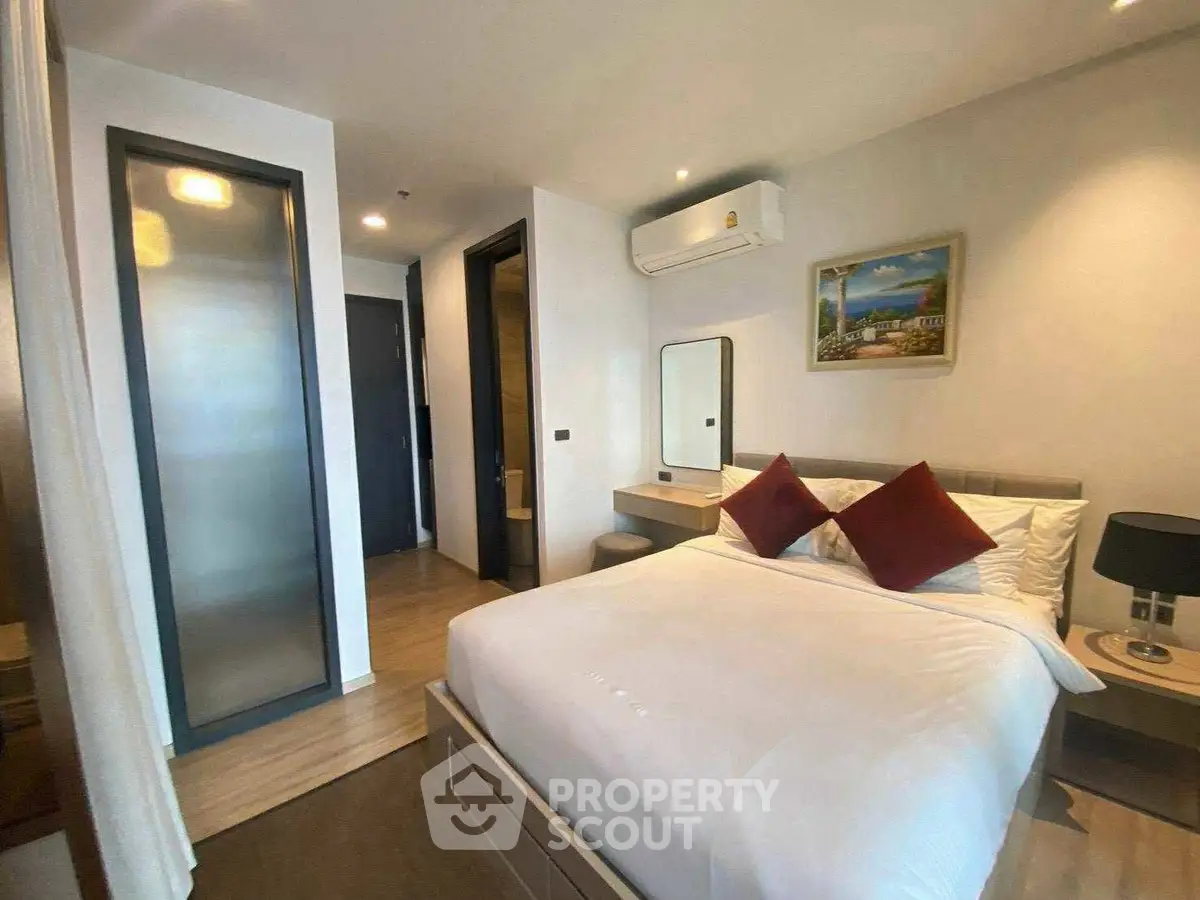 Modern bedroom with stylish decor and natural light, featuring a cozy bed and elegant furnishings.