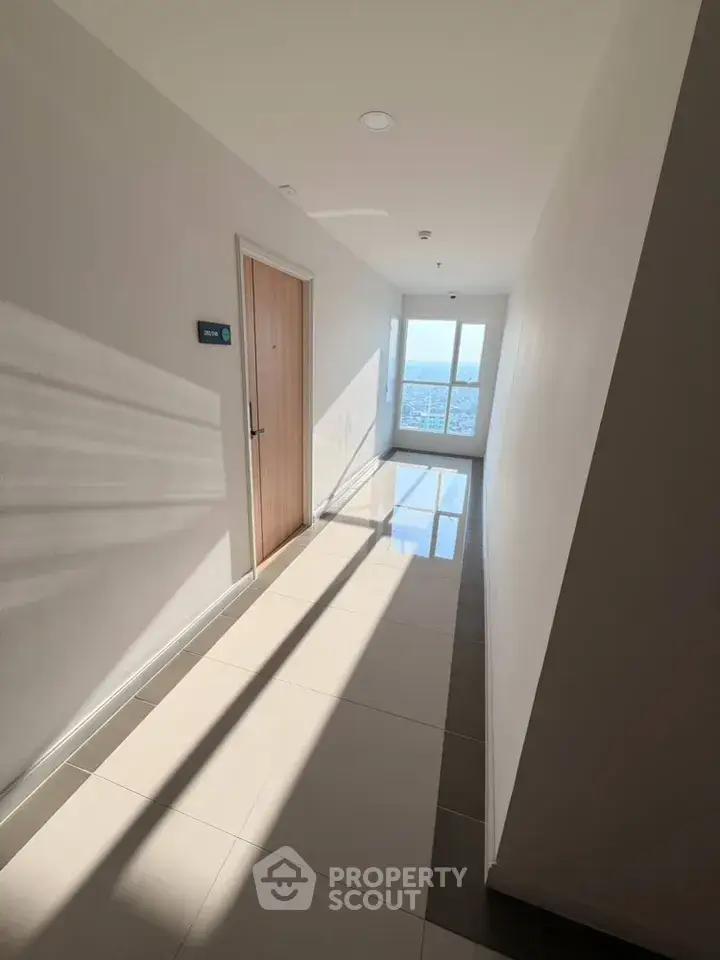 Bright corridor with glossy tiles and a window view in modern building