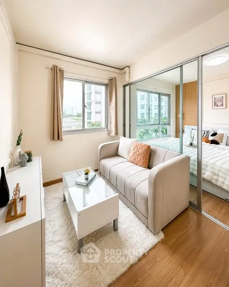 Chic modern living room with cozy sofa and glass partition leading to a bright bedroom.