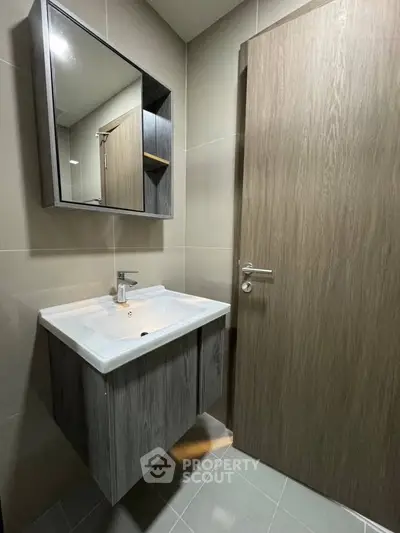 Modern bathroom with sleek vanity and mirror cabinet in a contemporary home.