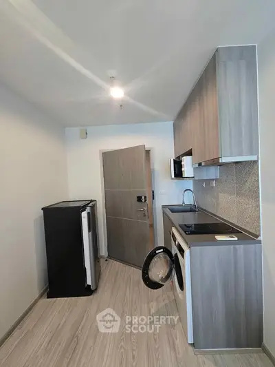 Modern kitchen with sleek cabinetry and built-in appliances in a compact layout.
