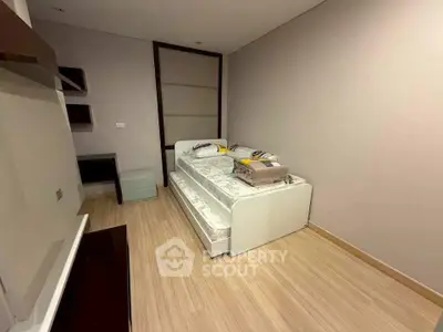 Modern minimalist bedroom with sleek design and wooden flooring, perfect for a cozy retreat.