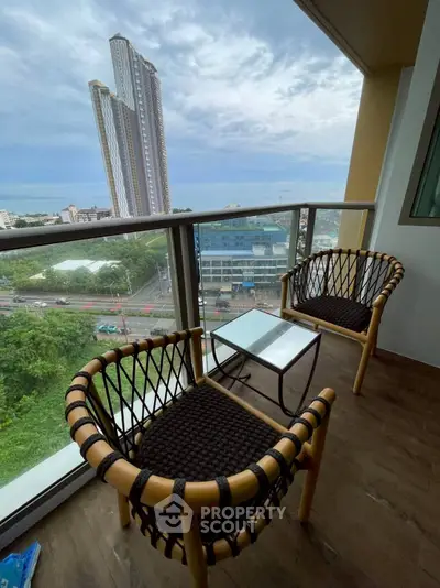 Stunning balcony view with modern chairs overlooking cityscape and skyscraper.