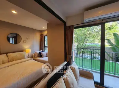 Cozy bedroom with balcony view, modern decor, and natural light in a stylish apartment.